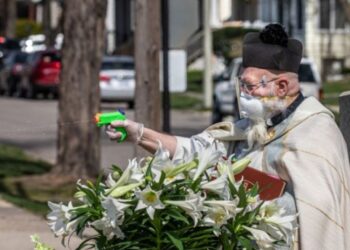 Sacerdote da la bendición con pistola de agua en Detroit