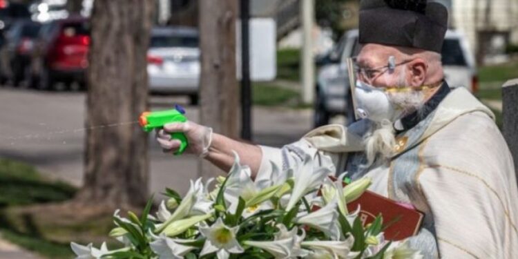 Sacerdote da la bendición con pistola de agua en Detroit