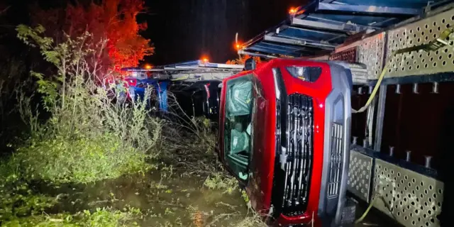Tráiler cargado con camionetas nuevas vuelca en la Valles-Tampico; conductor resulta lesionado